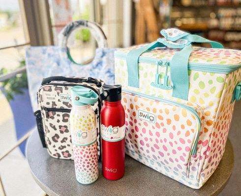 Colorful bags, tumblers and bottles in the gift shop